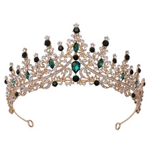 Detailed close-up of golden crown with sparkling green crystals and white teardrop gems