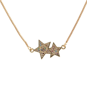 Detail of a golden double star necklace pendant with inlaid colorful zircon stones