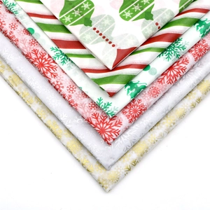Close-up of stacked Christmas tissue paper with festive snowflake and stripe patterns
