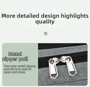 Detail showing smooth two-way metal zippers on gray fabric of the multipurpose diaper bag