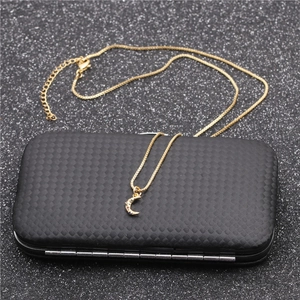 Collier doré tendance avec pendentif lune et pierres de zircon colorées sur boîte à bijoux