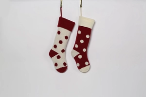 Détail de chaussettes de Noël tricotées à pois 3D rouges et blancs avec attaches