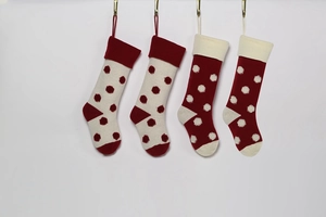 Vue détaillée de quatre chaussettes de Noël tricotées à pois 3D rouges et blancs