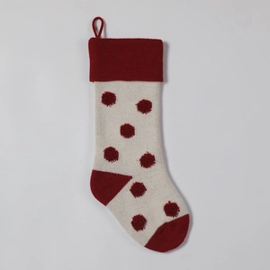 Détail d'une chaussette de Noël en tricot avec pois rouges en 3D et boucle de suspension