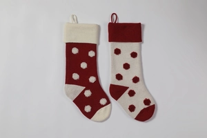 Détail de chaussettes de Noël en tricot à pois 3D rouges et blancs avec boucles d'attache