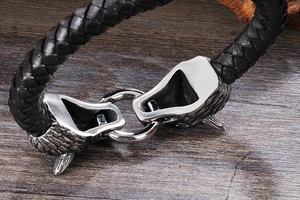 Détail macro du bracelet en cuir tressé noir avec fermoir loup en argent vieilli vintage
