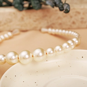 Macro shot showing gradient pearl sizes and lustrous texture of the vintage headband