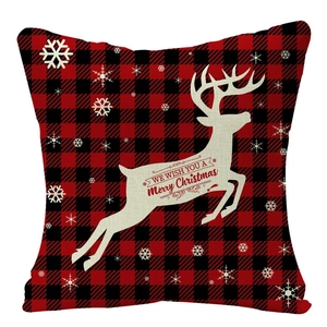 Détail de la housse de coussin en lin à carreaux rouge et noir avec renne blanc et flocon de neige
