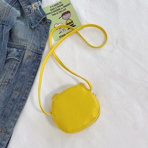 Mini yellow PU leather girls crossbody bag with cute animal ears on a denim background