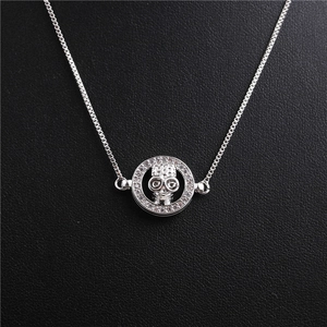 Detailed macro of a silver skull pendant necklace with sparkling crystal ring accents