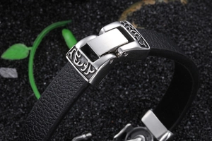 Macro shot of black leather bracelet with silver buckle and embossed metal details