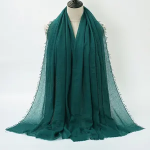 Sciarpa in cotone stropicciato verde scuro con bordo sfrangiato per un look minimalista