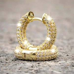 Macro shot of gold-plated hoop earrings featuring full pavé-set white zircon stones
