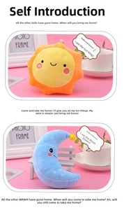 Detail of plush sun and moon pendants with embroidered faces on a pink surface