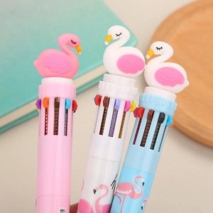 Three multi-color retractable ballpoint pens with pink flamingo toppers on a wooden tray