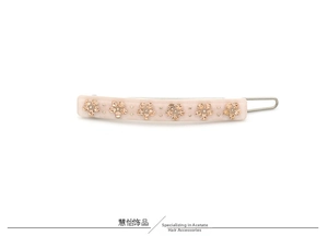 Detailed view of pink acetate hair clip featuring delicate champagne rhinestone flower patterns
