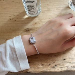 Detail of a 925 sterling silver bracelet with a large rectangular zircon on a woman's wrist