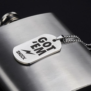 Silver military dog tag necklace with GOT EM print on a metallic flask background