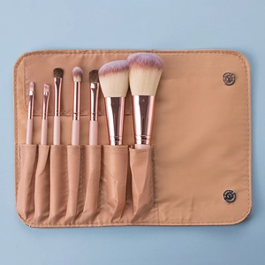 Detailed flat lay of a 7-piece rose gold makeup brush set in a beige foldable travel pouch