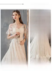 Detail of A-line wedding dress with lace embroidery, sheer neckline and cape sleeves