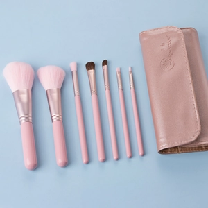 Detailed set of 7 portable pink makeup brushes with a matching leather travel pouch