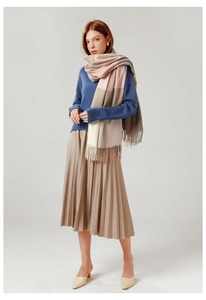 Detail shot of soft plaid scarf featuring pink and beige color blocks with tassel edges