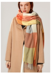Close-up of orange and yellow plaid scarf with fringe details and knit texture