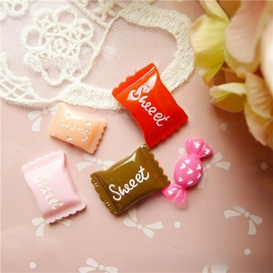 Macro view of colorful resin candy charms with Sweet text for DIY crafts accessories