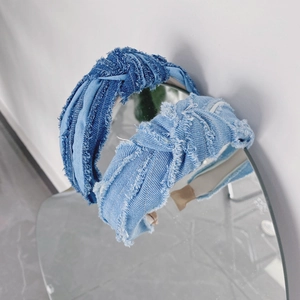 Détail de serre-têtes en denim noués aux bords effilochés sur un miroir circulaire