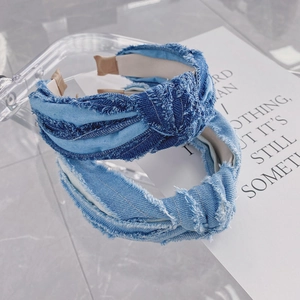 Détail de serre-têtes en denim avec nœud torsadé et bords effilochés en bleu clair et foncé