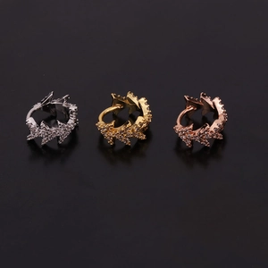 Detail of three snake-shaped ear cuffs in silver, gold, and rose gold with zircon stones