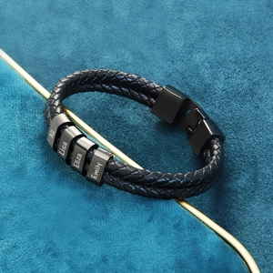 Close-up of personalized black braided leather bracelet with four engraved name beads