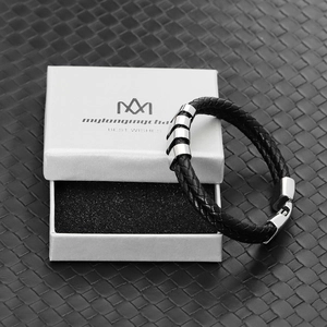 Detail of black braided leather men's bracelet with metal beads and branded gift box