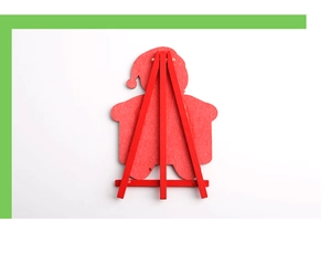 Close-up of a small red wooden easel stand holding a Santa figure on white background