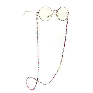 Handmade colorful beaded eyeglass chain with vintage gold frame glasses on white background