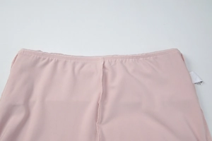 Detail shot of pink high-waist pants showing quality stitching and wash label