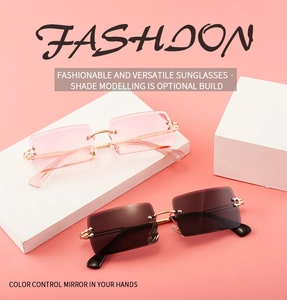 Detail view of pink and brown rimless square metal sunglasses on stylish geometric props