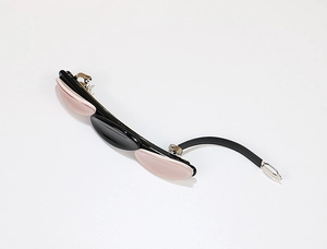 Detailed close-up of pink and black acetate triple oval geometric hair clip with silver metal barrette