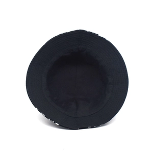 Double-sided bucket hat with coconut tree print and black inner lining for sun protection