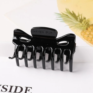 Detail of a large black wave-shaped hair claw clip with strong teeth for hair styling