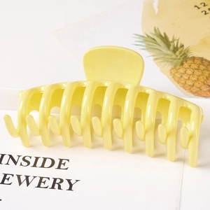Side view of a bright yellow hollow claw clip with multi-tooth structure for hair styling