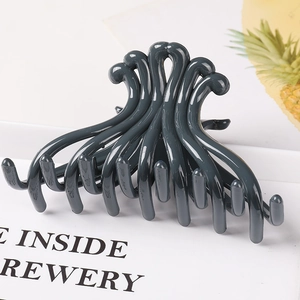 Detailed view of a dark grey geometric hair claw clip with a glossy finish and hollow design