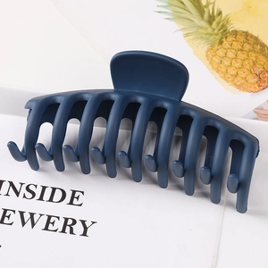 Close-up of a large navy blue matte claw clip with a unique geometric dragon bone design