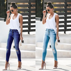 Detail of high waist multi-button fly and distressed ripped knees on slim denim jeans