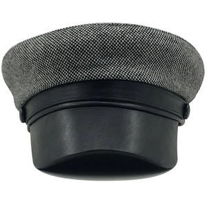 Detailed view of the woven wool texture and black leather brim on a vintage newsboy cap