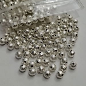 Macro shot of silver frosted metal round beads with textured finish and center holes