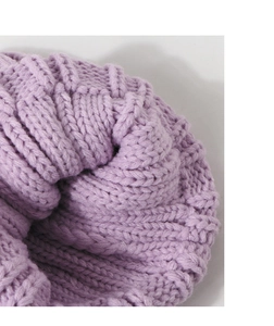 Gros plan du bonnet en tricot lavande montrant la texture épaisse des côtes et le fil