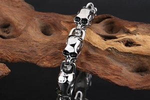 Gothic skull link bracelet in silver finish wrapped around rustic wood with black background