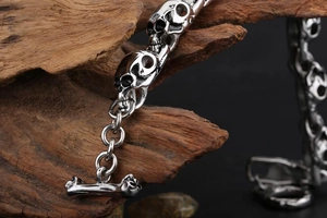 Detailed macro of silver skull link bracelet with vintage finish on dark wood