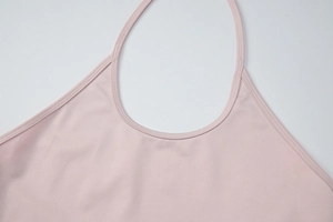 Detail view of the smooth pink knit fabric and neat stitching on the halter neck top